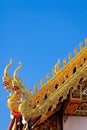 A detail of northern thai temple roof ,Naga , under clear blue sky Royalty Free Stock Photo