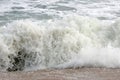 In detail, an ocean wave breaks on the shore