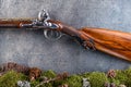 Detail of old antique long gun with forest still life on grey background, historical weapons