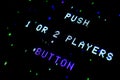 Detail on an old arcade video screen with text Push 1 or 2 players button