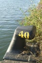 Black metal mooring bollard in marina and port terminal. Noray number 40th