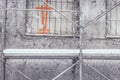 Detail of old building wall reconstructed in winter - plastic sheets on window, scaffold tubes covered with snow Royalty Free Stock Photo