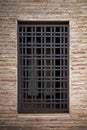 Old grille on a window in an old brick wall Royalty Free Stock Photo