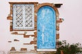 Detail of an old house with blue wooden door and white window - Facade of an old traditional house with deep blue wooden door and