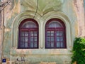 Twin Windows on Old Yellow and Green Stucco House, Constanta, Romania Royalty Free Stock Photo