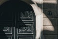 Detail of old italian weathered door in Milan on sunny day with shadow. Exterior part of european building. Royalty Free Stock Photo