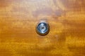 Detail of old lens peephole on wooden door background, for security in hotel. Royalty Free Stock Photo