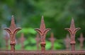 Detail of an old rusty fence with three fleur-de-lis Royalty Free Stock Photo