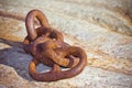 Detail of an old rusty metal chain anchored to a concrete block Royalty Free Stock Photo