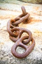 Detail of an old rusty metal chain anchored to a concrete block Royalty Free Stock Photo