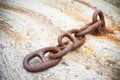 Detail of an old rusty metal chain anchored to a concrete block Royalty Free Stock Photo