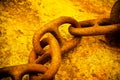 Detail of an old rusty metal chain anchored to a concrete block Royalty Free Stock Photo