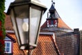 Tile roofs from the older house and a watchtower with a blurred street lamp in the foreground Royalty Free Stock Photo