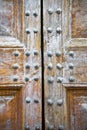 Detail of an old wooden doorway with metal nails reinforcement