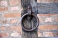 Detail of old wooden gate. Rusted iron ring handle