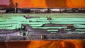 Detail of an old wooden window frame with peeling green paint, shades and nails on a sunny day