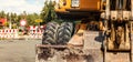 Detail on old yellow digger machine back, road closed signs, construction in progress background. Roadworks concept banner