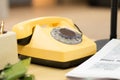 Detail on an old yellow retro telephone on a vintage desk in 80s 90s office Royalty Free Stock Photo