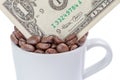 Detail of one US dollar banknote in a cup of coffee beans on white background. Royalty Free Stock Photo