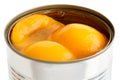 Detail of open can of peach halves in syrup on white .. Royalty Free Stock Photo