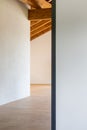 Detail of an open door, empty white room with exposed wood beams and hardwood floors Royalty Free Stock Photo