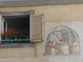 Open window with nearby a painting of young medieval lovers to Bergamo in Italy. Royalty Free Stock Photo