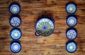 Detail of painted ornate pottery plates on wooden textured table in vintage style