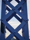 Detail of painted riveted bridge against blue sky. Royalty Free Stock Photo