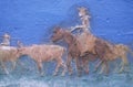 Detail of painting of cowboy on horse rounding up cattle on cattle drive