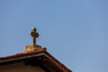 Cross on the roof of the church against the blue sky. Religious symbol.