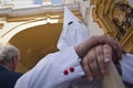 Detail penitent white holding a candle during Holy Week in the Arco del Postigo