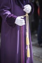 Detail penitent white holding a candle during Holy Week