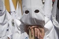 Detail penitent white holding a candle during palm sunday Holy Week in Arco del Postigo, Sevilla