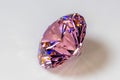 Detail photo focus stacking of a self-cut Cubic Zirconia with Pink color and Standard Round Brilliant cut, placed on a white acr