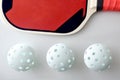 Detail of pickleball balls and red racket and isolated white