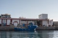 pier of the port of Mogan, there is a blue fishing boat