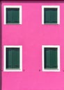 Detail with a pink colorful house window with green painted wooden shutters in Burano, Italy Royalty Free Stock Photo