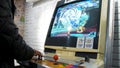 Detail of players hands interacting and playing with joysticks and buttons on an old arcade game in a gaming room Royalty Free Stock Photo