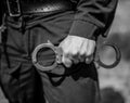 Detail of a police officer holding handcuffs. Royalty Free Stock Photo