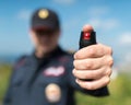 Detail of a police officer holding pepper spray.