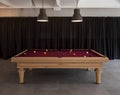 Detail of a pool table with balls and large lamps to illuminate the scene. In the background there are black curtains Royalty Free Stock Photo