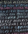 Detail of a portuguese menu written in multicolored chalk on a black chalkboard Royalty Free Stock Photo