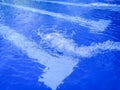 Detail of a powerful water jet filling an olympic swimming pool with white lane lines in the bottom Royalty Free Stock Photo