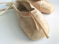 Close-up antique ballet slippers worn and well-used on white background. Detail of professional ballet toe shoes Royalty Free Stock Photo