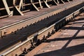 Detail of railway tracks on old metal bridge, sun casting shadow Royalty Free Stock Photo