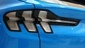 Detail of rear LED lights of modern electric american compact crossover car Ford Mustang Mach-E AWD, light blue color