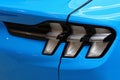 Detail of rear LED lights of modern electric american compact crossover car, light blue color, displayed on automobile expo. Royalty Free Stock Photo