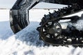 Detail of the rear of a snowmobile with wheel and mudguard. The mechanism of a large machine for moving in deep snow. Close-up