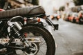 Detail of the rear wheel and leather seat of the motorbike parked in the street of Bilbao during the morning Royalty Free Stock Photo