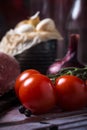 Detail of red cherry tomatoes next to pork tenderloin on wooden board Royalty Free Stock Photo